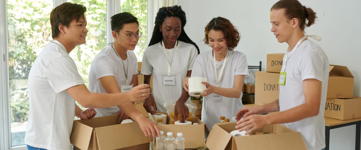 Diverse group of volunteers packing donated products in boxes for people in need